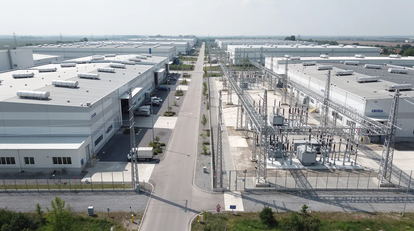 An aerial view of an industrial estate showcases multiple electrical substations and utility corridors nestled between various factory buildings, highlighting the interconnectedness of commercial spaces and the careful planning required for such construction projects. This image reflects the complexity of managing site conditions and coordinating with relevant authorities for successful renovations and operations.